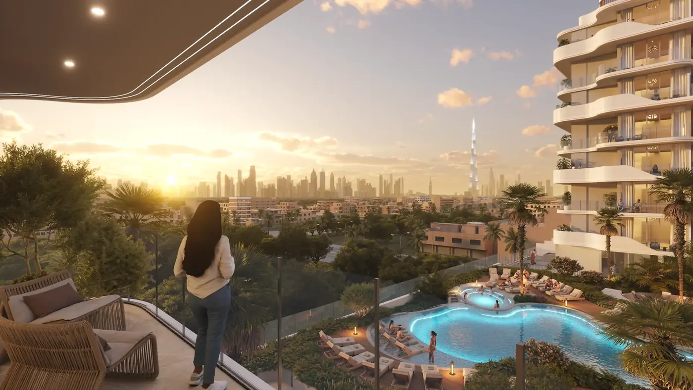 Resident on a balcony looking out over the podium pool and the Dubai skyline at sunset